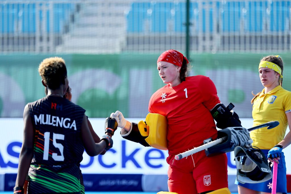 Katia Pokido geeft een hand aan de medespelers aan het einde van de wedstrijd. Dit is een wedstrijd die plaats vindt tijdens de oorlog.